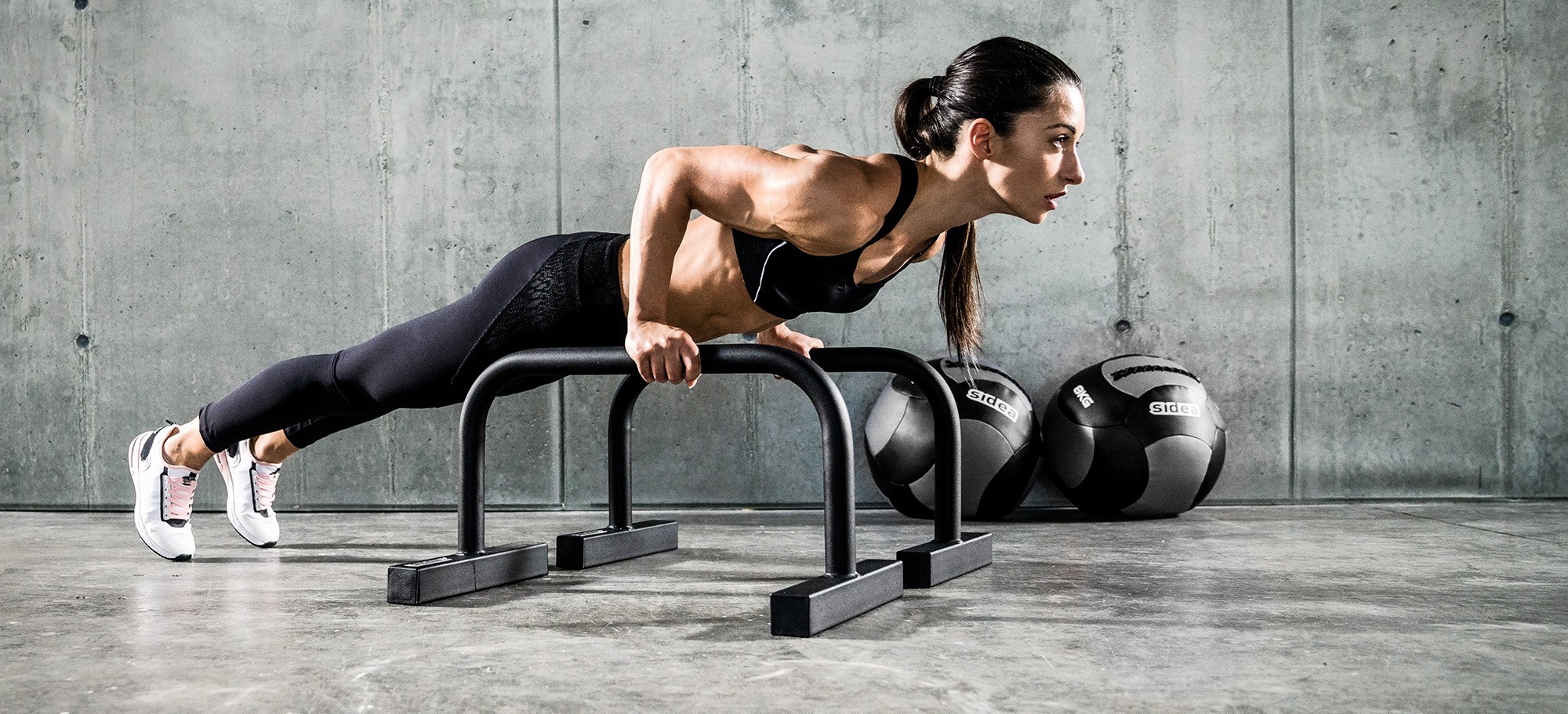 Athlete performing bodyweight exercises on Sidea commercial steel parallettes