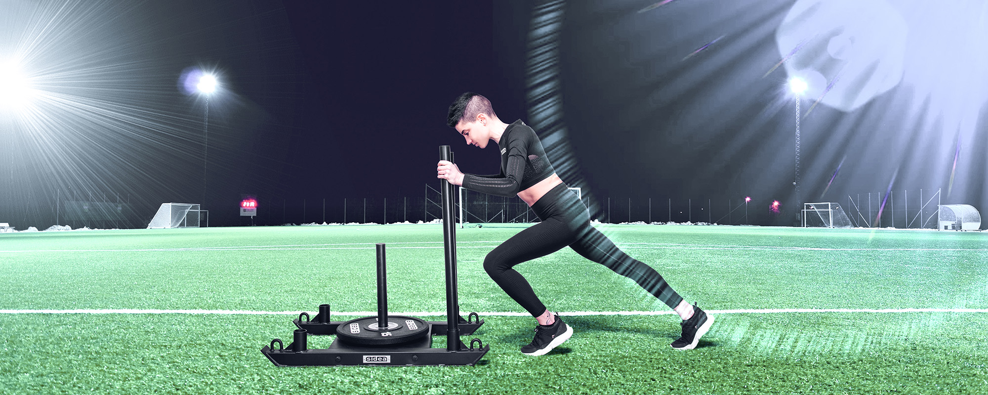 Athlete pushing a Sidea commercial weight sled on artificial gym turf