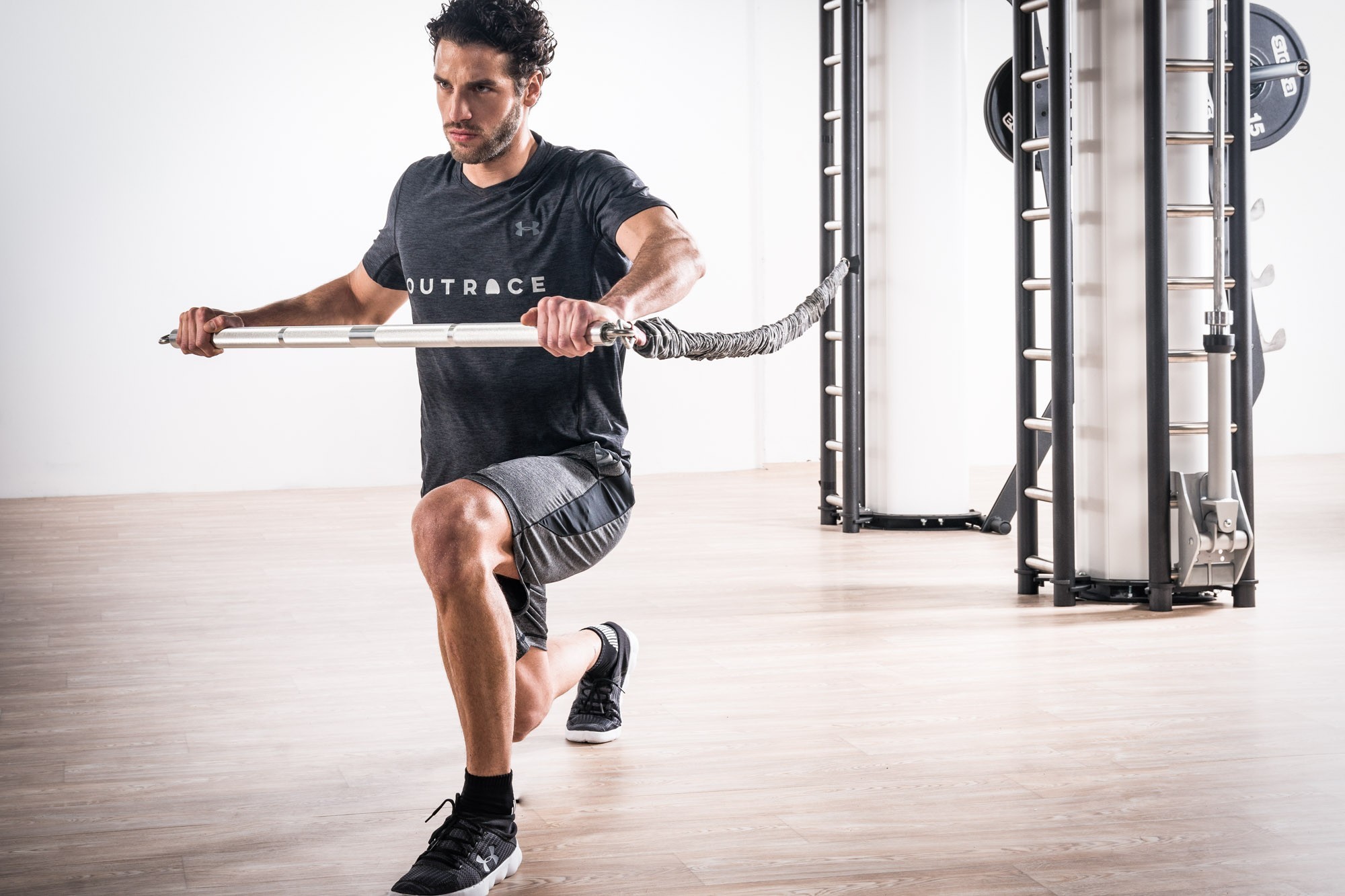 Athlete using a metal Sidea exercise bar for functional mobility training in a gym