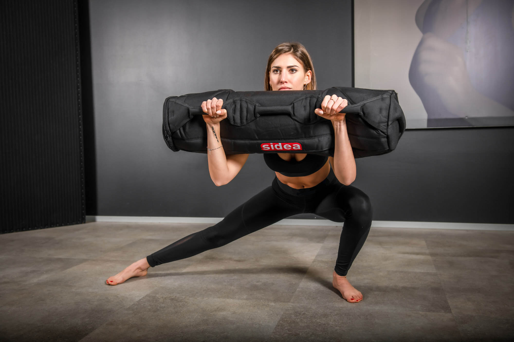 Athlete performing clean and press movements with Sidea commercial fitness sandbags