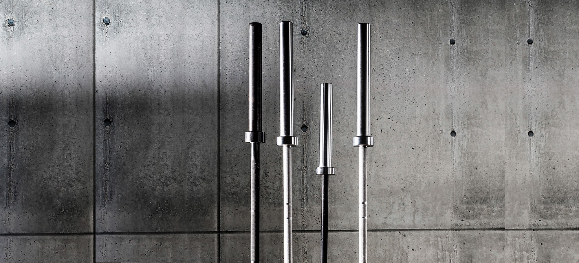 Sidea Olympic barbells resting on a rack in a commercial weightlifting facility