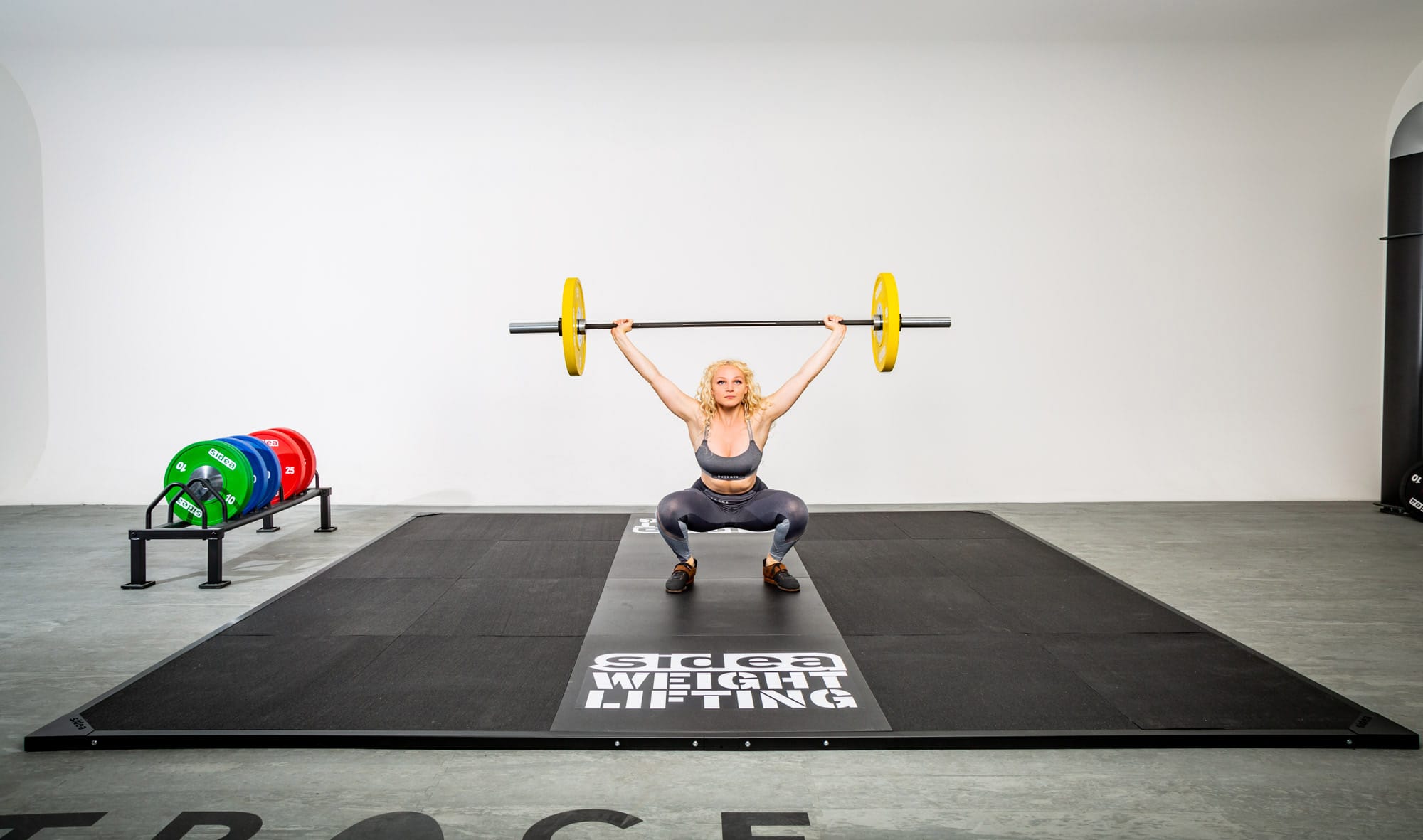 Athlete snatching barbell on a Sidea Olympic weightlifting platforms